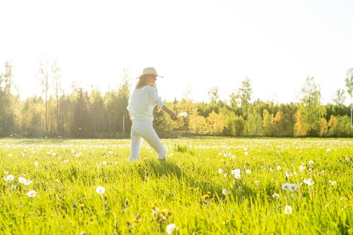 sommar äng maskros motljus kvinna tjej vit grön silhuett ljus high key hatt gräs